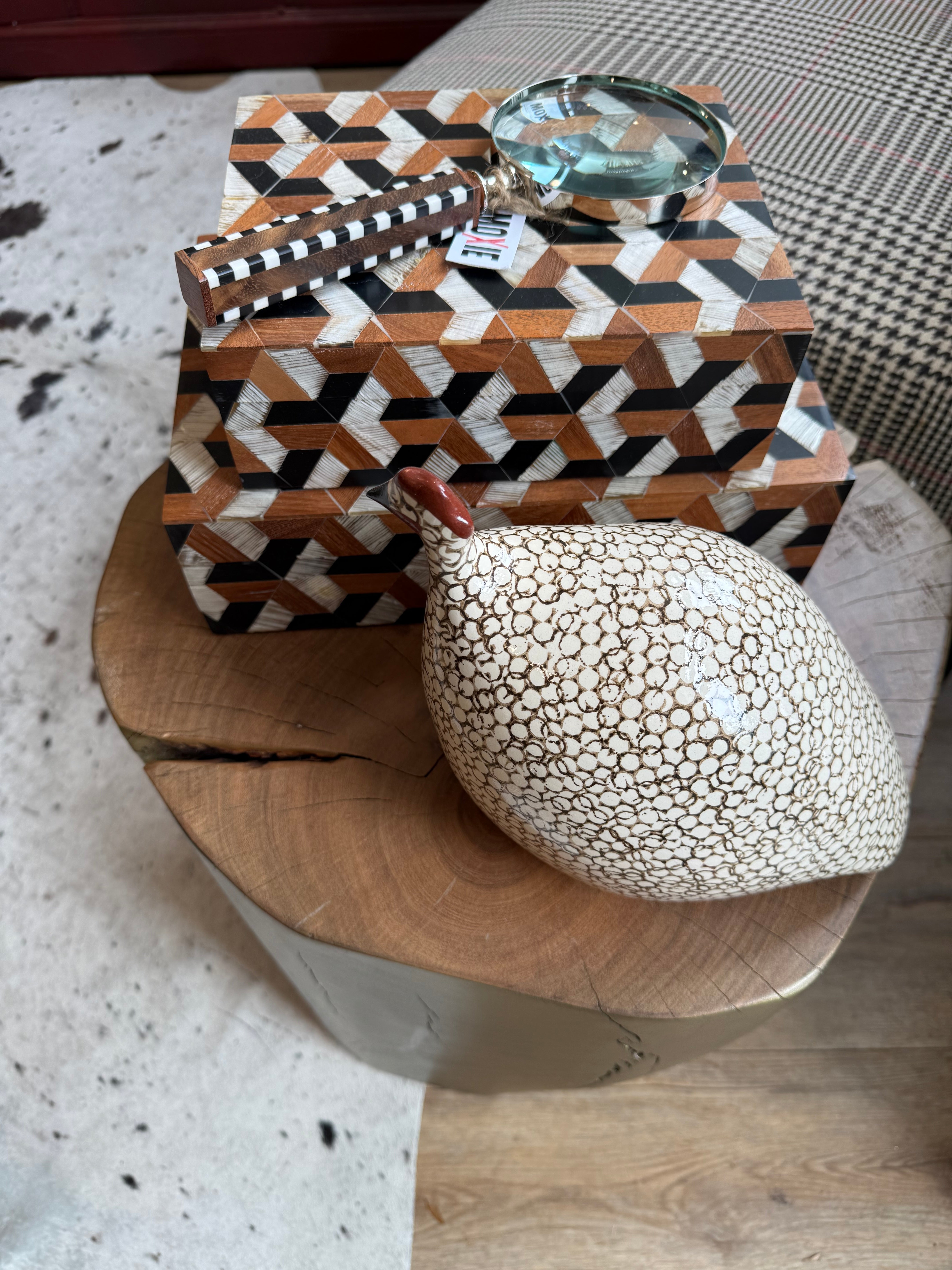 Decorative item with a textured sphere and patterned box on a textured surface
